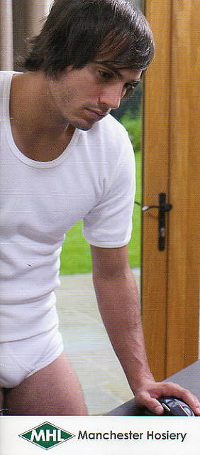 Model in a Manchester Hosiery T shirt and pants looks at something like a paper - maybe job vacancies